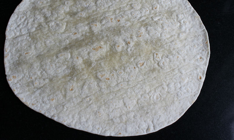 Laid out tortilla wrap on chopping board