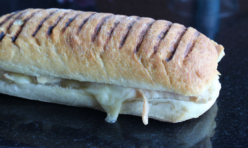 Cooked panini with melted Cheddar cheese