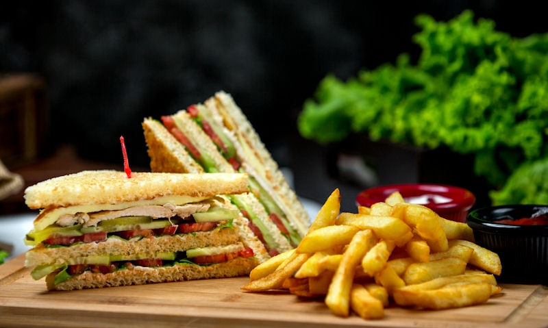 Chicken, avocado sandwich served with french fries