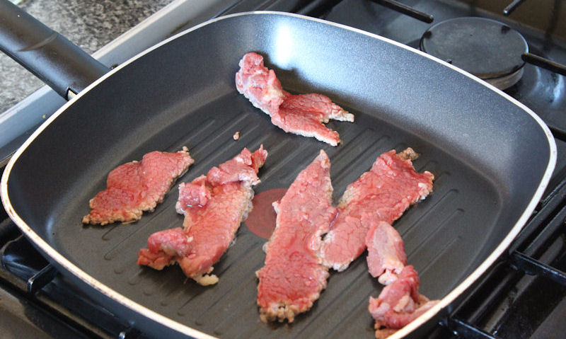 Raw beef strips in grill pan