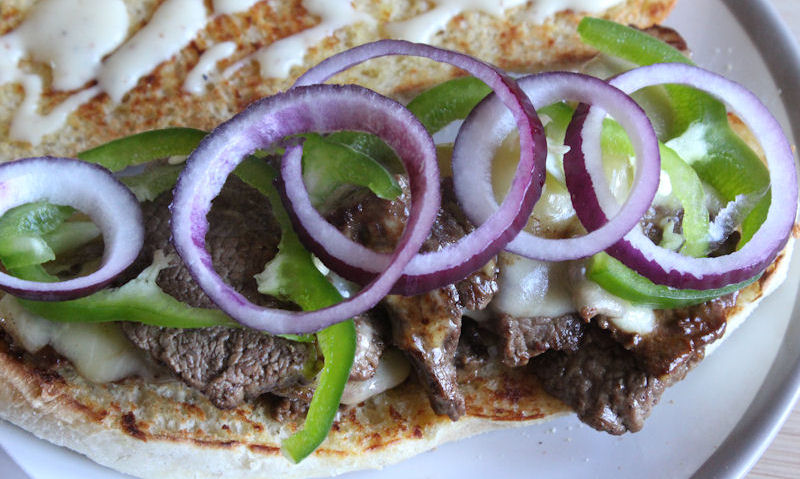 Sliced red onion on green peppers