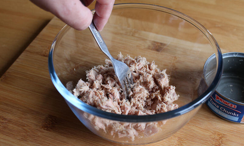Breaking up tuna chunks to glass Pyrex bowl